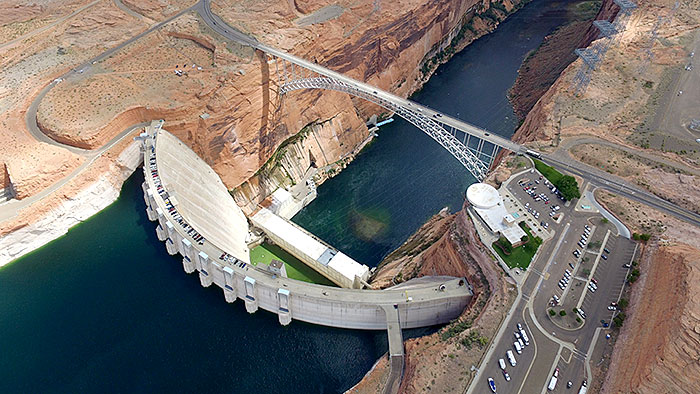 An aerial view of a river dam that is built in an arc.